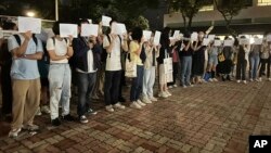 资料照片: 2022年11月28日香港中文大学举行乌鲁木齐致命火灾遇难者纪念活动,抗议者举起白纸