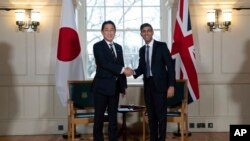 2023年1月11日,英国首相苏纳克(右)在伦敦塔举行的双边会议开始时与日本首相岸田文雄握手。(美联社照片)