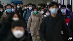 资料照 - 2022年12月20日的北京街头,带口罩的通勤者在交通高峰期匆忙赶去上班。在突然放开了执行将近3年的严格封控政策后,中国多地新冠感染病例暴增,并且出现了奥密克戎病毒的变异毒株。