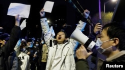 2022年11月28日,在新冠病毒疫情持续扩散之际,北京民众为乌鲁木齐火灾遇难者守夜后,举着白纸抗议中共当局的封控限制。