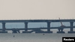 资料照片:视图显示刻赤海峡中因爆炸而受损的克里米亚大桥的一部分。(2022年10月17日)