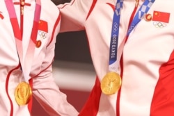 中国场地自行车女子团体赛两名金牌得主在东京奥运会领奖台上违反奥林匹克宪章,佩戴中共前领导人毛泽东的像章。(2021年8月2日)