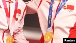 中国场地自行车女子团体赛两名金牌得主在东京奥运会领奖台上违反奥林匹克宪章,佩戴中共前领导人毛泽东的像章。(2021年8月2日)