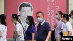 上海民众走过街头树立的一面中国领导人习近平的宣传画。(2022年8月31日)