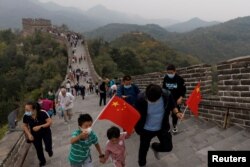 中国国旗日游客手拿国旗爬长城。(2022年10月1日)