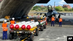 台湾军队士兵站在F16V战机前,准备进行装载美制AGM-84鱼叉反舰导弹及AIM-120和AIM-9空空导弹的训练。(2022年9月16日)