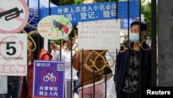 上海封城后居民在关闭的小区大门后等候递送的食物。(2022年4月13日)