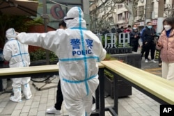 2022年4月1日,上海静安区的警察指挥居民排队等待核酸检测。