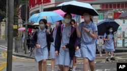 香港小学生戴着口罩去学校上学接受面对面教学。(2022年4月19日)