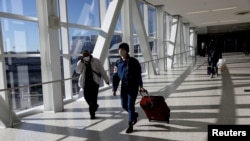 资料照:新冠疫情期间美国纽约的肯尼迪国际机场旅客都戴着口罩。(2021年11月16日)