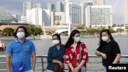 戴着口罩的游客游览新加坡鱼尾狮公园。(2020年1月28日)