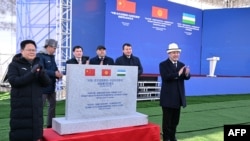 2024年12月27日,吉尔吉斯斯坦总统萨德尔·贾帕罗夫(右)、中国国家发展改革委主任郑栅洁(左)等官员出席中吉乌铁路开工。(吉尔吉斯斯坦总统办公室提供/法新社发布)