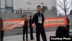 袁冬等人2013年3月31日在北京西单展示反腐横幅,征集签名呼吁官员公示财产。(网络图片)