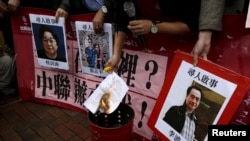 香港示威者在中联办外面要求调查铜锣湾书店职工和店主失踪案, 右一是李波照片。(2016年1月3日)