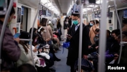 戴着口罩的乘客乘坐上海地铁去上班。(2020年3月9日)