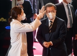 韩国总统文在寅戴着口罩在首尔的国会议事堂接受体温检测。(2020年2月28日)