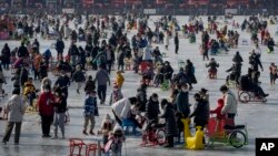 2023年1月30日,游客们在北京冰冻的后海湖上滑冰。(美联社)
