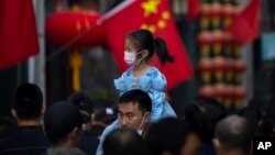 资料照:在北京一个购物区一名小女孩骑在一个男子的肩头上逛街。(2022年10月7日)