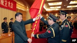 资料照片:中国官方公布的照片显示,中共领导人习近平在北京举向时任火箭军首届司令的魏凤和上将授予军旗。(2015年12月31日)
