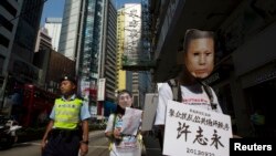 香港民主派抗议者戴着象征许志永的面具在香港街头抗议,要求中国释放政治犯。(2013年10月1日)