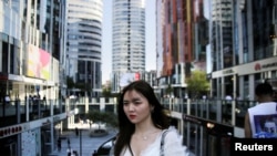 一名年轻女子2018年6月28日在北京三里屯Soho住宅和商业综合体散步。(路透社)