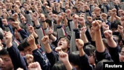 南京一所高中的学生在听关于升学的励志演讲时喊口号:“我必须上大学!”“爸爸妈妈我爱你!”