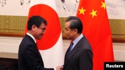 王毅(右)2018年1月28日会见到访的日本外相河野太郎(路透社)