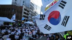 2024 年 12 月 15 日,韩国首尔,参加者举着标语呼吁宪法法院罢免总统尹锡烈。标语上写着“立即逮捕”。