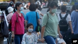 台湾台北街道上的行人戴着口罩预防新冠病毒。(2020年7月28日)
