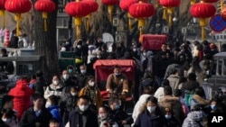 2023年1月30日,中国放弃了对新冠病毒的“零容忍”政策后,北京后海一条熙熙攘攘的街道,传统的三轮儿在人群中穿行。(美联社)