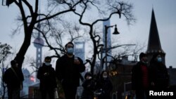 上海不断出现新冠病例后,行人戴着口罩行走在上海街头。(2022年2月14日)