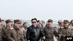 朝中社提供的照片说,朝鲜领导人金正恩在新型洲际弹道导弹发射现场与朝鲜军人一起行走(2022年3月24日)