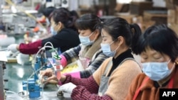 中国安徽省阜阳市临泉县的工人在制造扬声器的生产线上工作。(2022年3月31日)