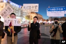 在美国首都华盛顿白宫附近举行抗议的人群手举要求共产党下台的标语。(2022年12月4日)