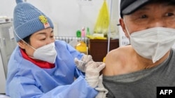 中国山东省青州的医护人员在给一名男子接种新冠疫苗。(2022年12月29日)