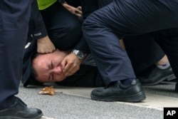 资料照:上海警察把一名抗议中国严厉防疫政策的青年压倒在地。(2022年11月27日)
