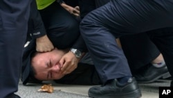 上海警察把一名抗议中国严厉防疫政策的青年压倒在地。(2022年11月27日)