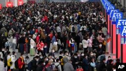 广东深圳南站大厅内,旅客们人们带着口罩和行李,熙熙攘攘挤满大厅,等待买票和登车。(2023年1月7日)