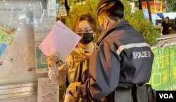 化名Anna的中国内地留学生趁12月4日中国国家宪法日,在维园举白纸被警员截查 (美国之音/汤惠芸)