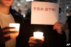 在美国首都华盛顿白宫附近举行抗议的人群手举反对中国政府严厉防疫政策的标语。(2022年12月4日)