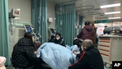 中国河北廊坊第四人民医院急诊室内病人家属聚在病人床前。(2022年12月22日)
