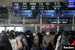 中国武警士兵在上海火车站里指挥春运人潮排队等候。(2023年1月16日)