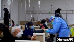 上海一家医院的医生正在帮助一名病人打点滴。(2023年1月5日)