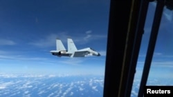 中国一架J-11战斗机在南中国海上空拦截一架美国空军RC-135飞机。(2022年12月21日)