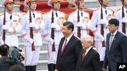 资料图片:2017年11月12日,中国国家主席(中)和越共总书记阮富仲在越南河内总统府举行的欢迎仪式上。