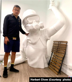 周小龙与巨型雕像合照 (图片来源:周小龙脸书网站)