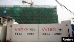 上海一处建筑工地的大门上万科的标志。(资料照片)