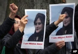 流亡伊朗人举着在伊朗警察局死亡的女子阿米尼(Mahsa Amini)的照片在伊朗驻柏林大使馆外抗议。(2022年9月20日)