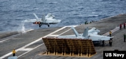 资料照片:F/A-18F超级大黄蜂战斗机从在南中国海航行的里根号航母甲板起飞。(2022年7月13日)