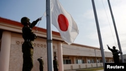 日本冲绳一个军营里的自卫队成员在晚间举行降旗仪式。(2022年4月20日)